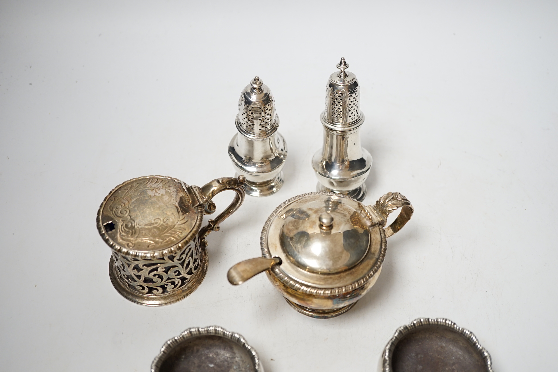 A collection of small silver items to include a pair of Georgian cauldron salts, two mustard pots including London, 1828 and London, 1850 and two George II pepperettes, London, 1749 and 1749, one a.f.